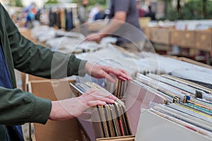 Pick and select second hand phonograph discs in the paper box at flee market.