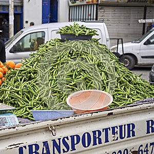 Pick-up truck with a mountain of beans on the truck bed is parked at the side of the road, waiting for bean buyers