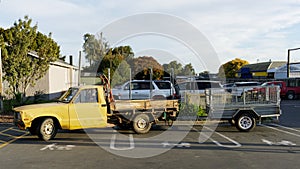 A pick up truck and trailer parked across three push chair and baby parking bays