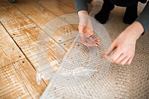 Picking broken bottle glass on wooden floor