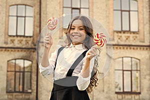 Picking flavour is hardest part. Schoolgirl choosing sweets. Happy kid with sweet candy. Kid child holding lollipops