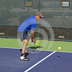 Pickleball Action - Man in Blue Preparing to Hit A Backhand photo