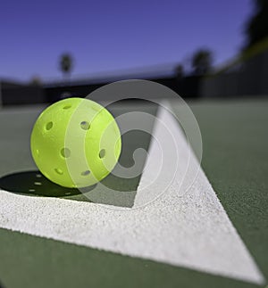 Pickleball on a court with white lines.