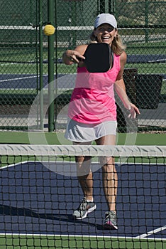 Pickleball - Smiling Female Hitting Ball At Net