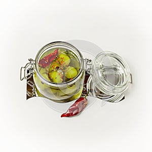 Pickled cucumbers with spices and pepper in an open glass jar