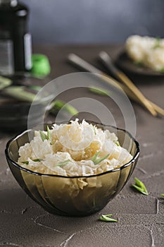 Pickled and fermented white mushroom Tremella fuciformis in a glass plate on a dark background