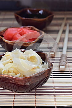 Pickled ginger slices and wooden chopsticks. Ingredient for sushi. Healthy food. Traditional Japanese condiment.