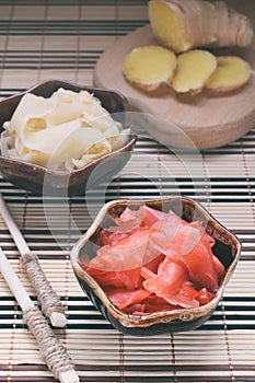 Pickled ginger slices and wooden chopsticks. Ingredient for sushi. Healthy food. Traditional Japanese condiment.