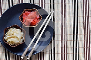 Pickled ginger slices and wooden chopsticks. Ingredient for sushi. Healthy food. Traditional Japanese condiment