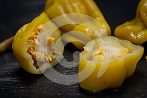 Pickled Golden Greek Peppers, Pepperoncini or Friggitelli sweet Italian chili pepper on natural stone background.