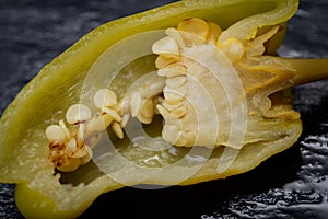 Pickled Golden Greek Peppers, Pepperoncini or Friggitelli sweet Italian chili pepper on natural stone background.