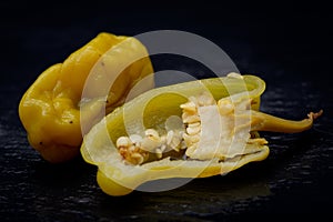 Pickled Golden Greek Peppers, Pepperoncini or Friggitelli sweet Italian chili pepper on natural stone background.