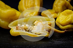 Pickled Golden Greek Peppers, Pepperoncini or Friggitelli sweet Italian chili pepper on natural stone background.