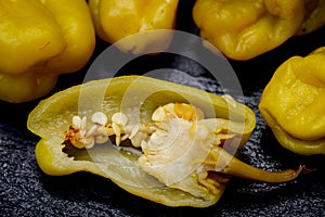 Pickled Golden Greek Peppers, Pepperoncini or Friggitelli sweet Italian chili pepper on natural stone background.