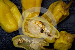 Pickled Golden Greek Peppers, Pepperoncini or Friggitelli sweet Italian chili pepper on natural stone background.