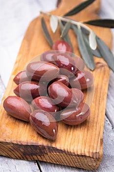 Pickled greek kalamata olives on wooden board