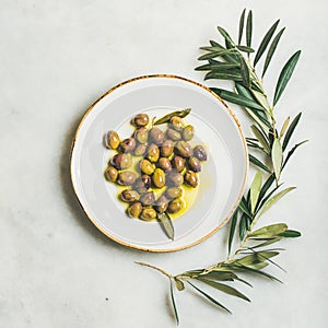 Pickled green Mediterranean olives in virgin olive oil, square crop