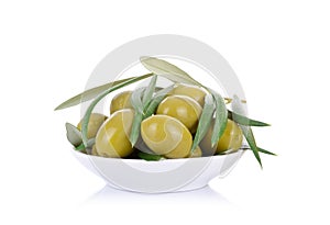 Pickled green olives in a bowl and olive tree branch