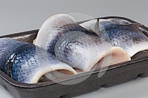 Pickled herring fillets on skin on foam food tray