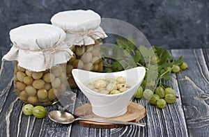 Pickled homemade gooseberries in a jar and in  gravy boat