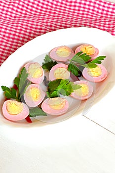 Pickled peeled hard-boiled quail eggs, stained pink by grated beet