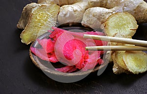 Pickled pink ginger and fresh root on the table.