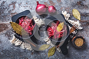 Pickled red onions in bowl on a gray background. Appetizer, condiment or topping, healthy fermented food photo