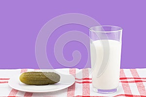 Pickled salty cucumber with a glass of milk