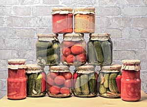 Pickled tomatoes, canned cucumbers and lecho in glass jars. Concept of home canning vegetables for the winter