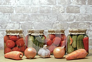 Pickled tomatoes, canned cucumbers and lecho in glass jars. Concept of home canning vegetables for the winter