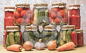 Pickled tomatoes, canned cucumbers and lecho in glass jars. Concept of home canning vegetables for the winter