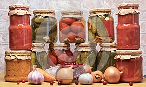 Pickled tomatoes, canned cucumbers and lecho in glass jars. Concept of home canning vegetables for the winter