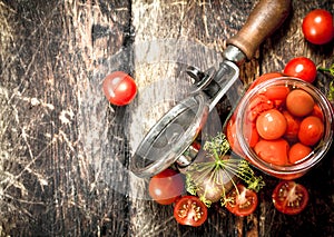 Pickled tomatoes with herbs spices and seamer.