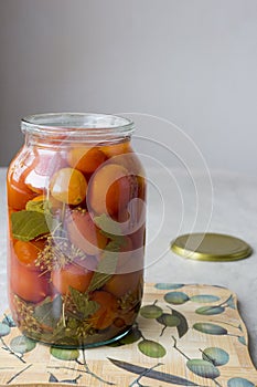 Pickled tomatoes in an open jar