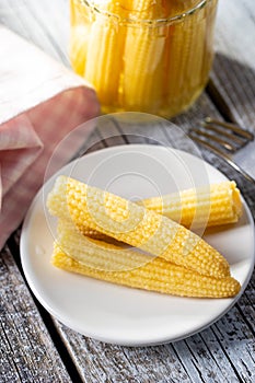 Pickled young baby corn cobs on plate