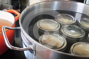 Pickling jars in a pot full of water photo