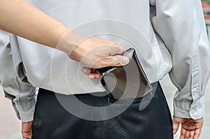 Pickpocket stealing a mans wallet from back pocket