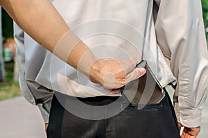 Pickpocket stealing a mans wallet from back pocket