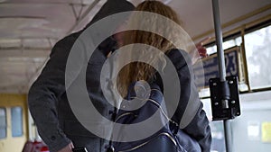 Pickpocket stealing phone from a woman`s handbag in tram or bus