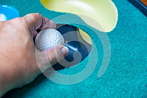 Pickup a golf ball on putting mat