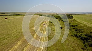 a pickup truck drives through the field to control the harvest