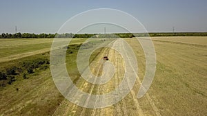 a pickup truck drives through the field to control the harvest