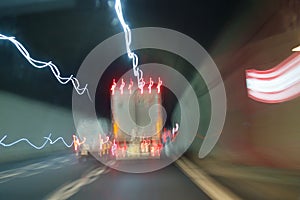Pickup truck overtakes truck inside the highway tunnel. Wavy light trails effect in color.