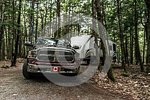 A pickup truck towing a camper RV trailer during summer time at Kejimkujik National Park Nova Scotia Canada