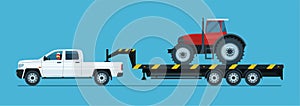 A pickup truck tows a tractor on a trailer isolated.