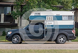 A pickup truck with a truck box camper during summer