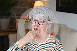 Picky senior woman gagging at home