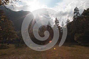 A picnic area or place in a beautiful valley sourounded by mountains in the sunset