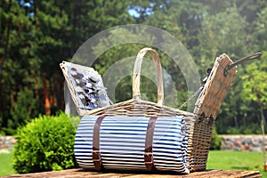 Picnic basket with blanket on  table in garden
