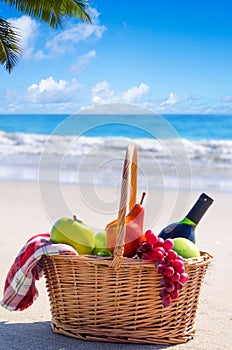 Picnic basket with fruits by the ocean